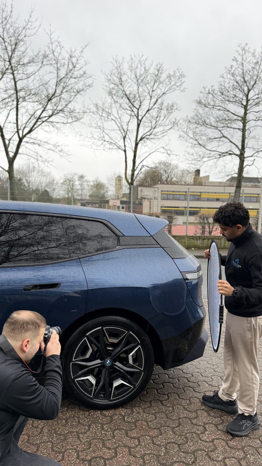 GutaGo24 Sachverständiger fotografiert blauen BMW iX bei Begutachtung